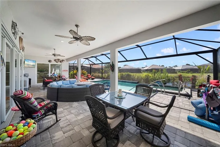 Expansive screened-in lanai with a swimming pool, paved flooring, and ceiling fans