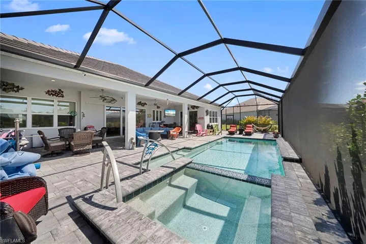 The property features a screened-in lanai with a swimming pool and an integrated spa