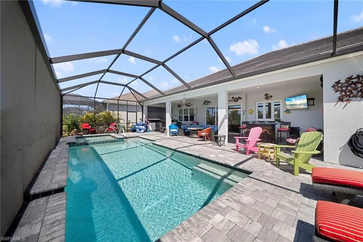 This property features a screened-in swimming pool and a paved patio area