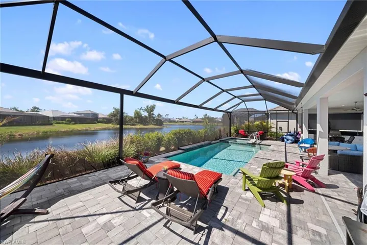The property features a screened-in pool area with a paved patio, offering a clear view of the water
