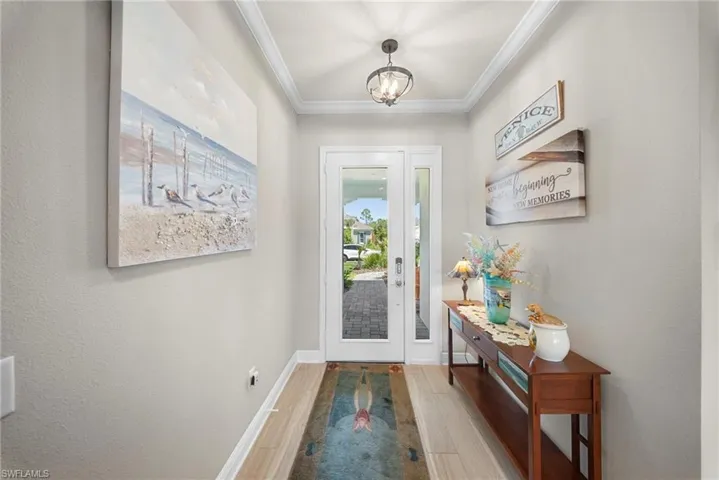 The entryway features light-toned flooring and a decorative overhead light fixture