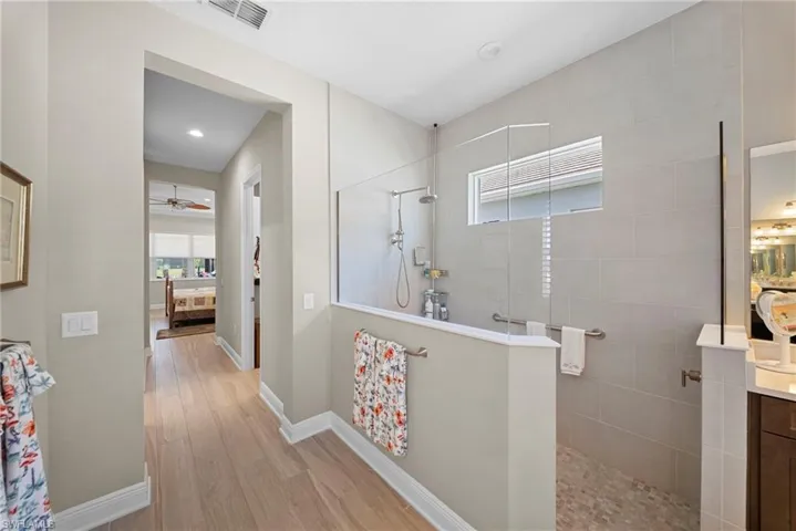 This property features an open-concept bathroom with a glass-enclosed shower, complete with tiled walls and a window