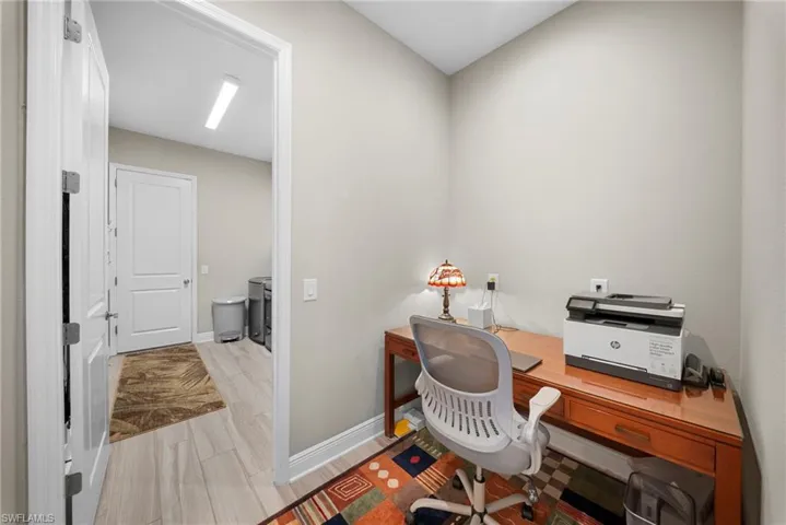 This versatile room features light-toned walls and wood-look flooring, providing a functional space
