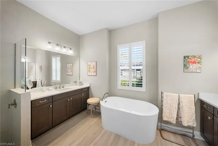 This bathroom features a large vanity with two sinks, dark cabinetry, and white countertops