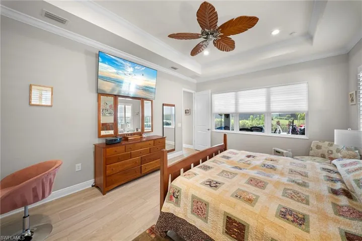 The room features a tray ceiling with recessed lighting and a ceiling fan