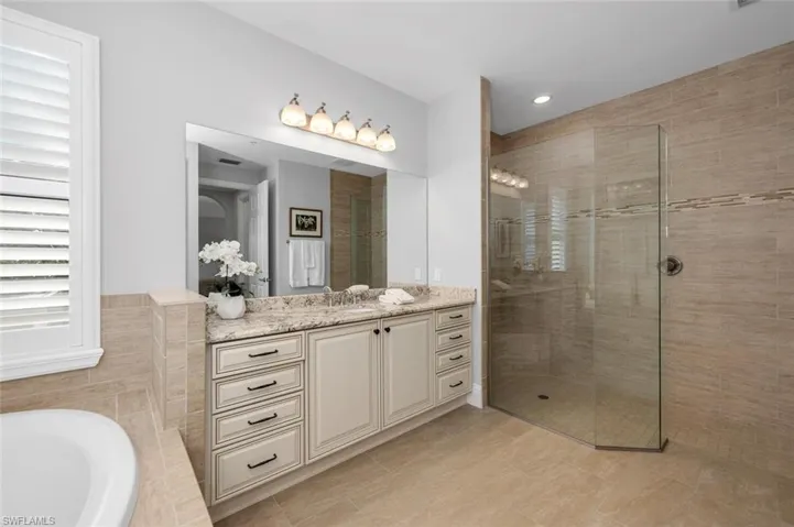 Bathroom featuring vanity and plus walk in shower