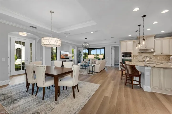 Dining space featuring a tray ceiling, light hardwood / wood-style flooring, and ornamental molding
