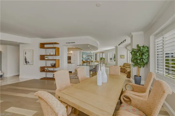 Dining space featuring light wood-type flooring, ornamental molding, and hanging lights