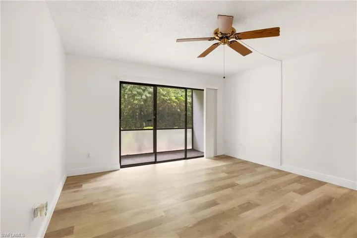 Unfurnished room featuring light wood-style floors, a textured ceiling, and ceiling fan
