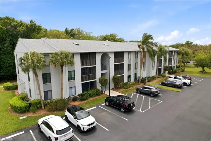 View of apartment building / complex with uncovered parking