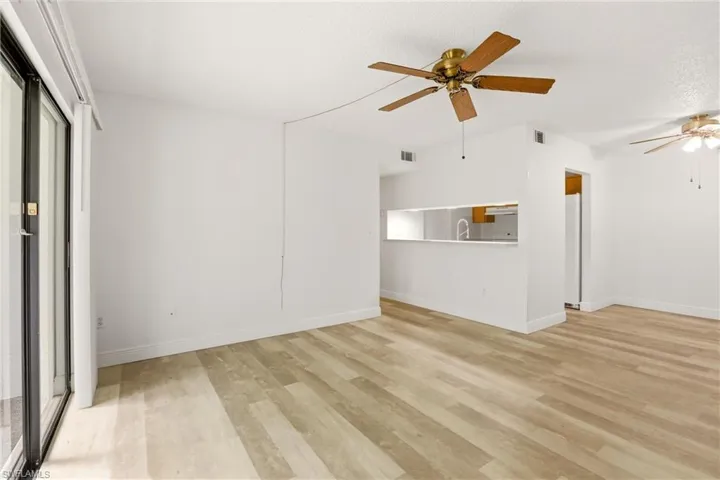 Unfurnished living room with a ceiling fan and light wood-style flooring