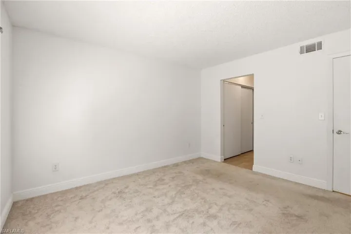 Spare room with light carpet and a textured ceiling