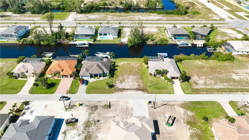 Canal-front property featuring a clear, undeveloped lot ready for new construction