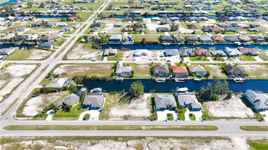 Aerial perspective showcasing a residential area featuring multiple canals, numerous properties with individual docks, and a grid street pattern