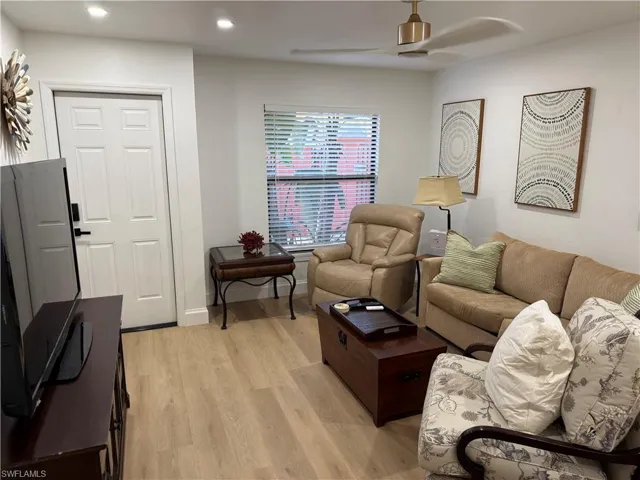 Living area with a ceiling fan, light wood finished floors, and recessed lighting