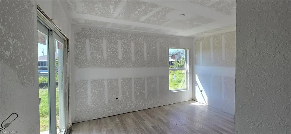 Empty room featuring wood finished floors and a textured wall