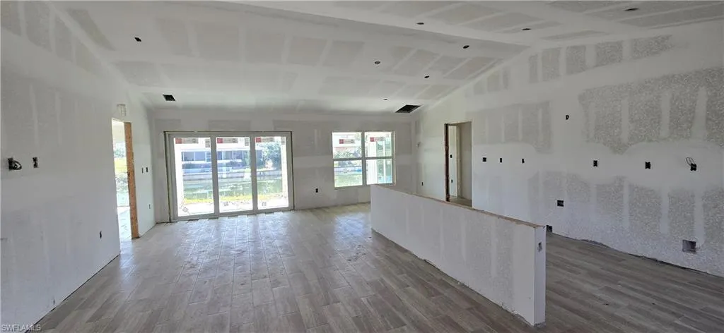 Kitchen featuring lofted ceiling, visible vents, wood finished floors, and open floor plan