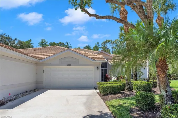 Ranch-style house with driveway, an attached garage, a tile roof, and stucco siding
