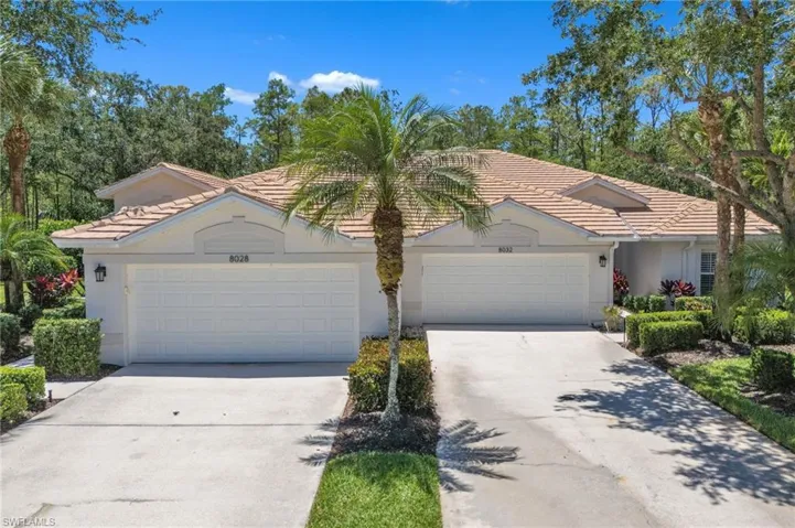 Single story home with concrete driveway, a tiled roof, stucco siding, and an attached garage