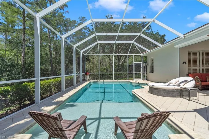 Swimming pool with a patio and glass enclosure