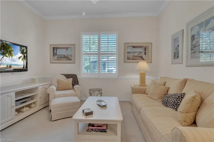 Living area with light colored carpet and ornamental molding