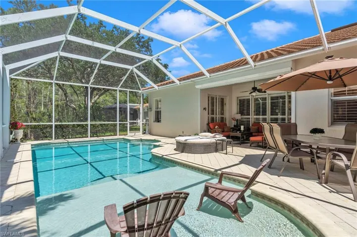 Swimming pool featuring a ceiling fan, a patio area, and glass enclosure