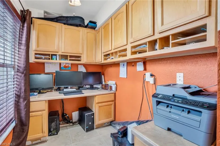 Office area featuring light tile patterned floors and built in desk