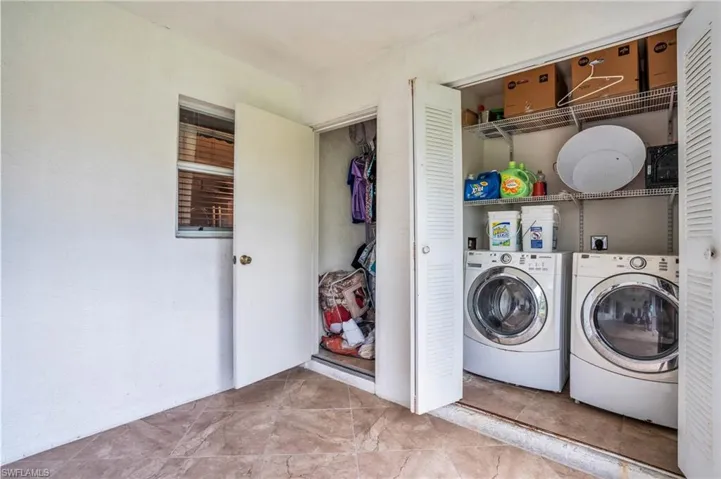 Laundry room with light tile patterned floors and independent washer and dryer