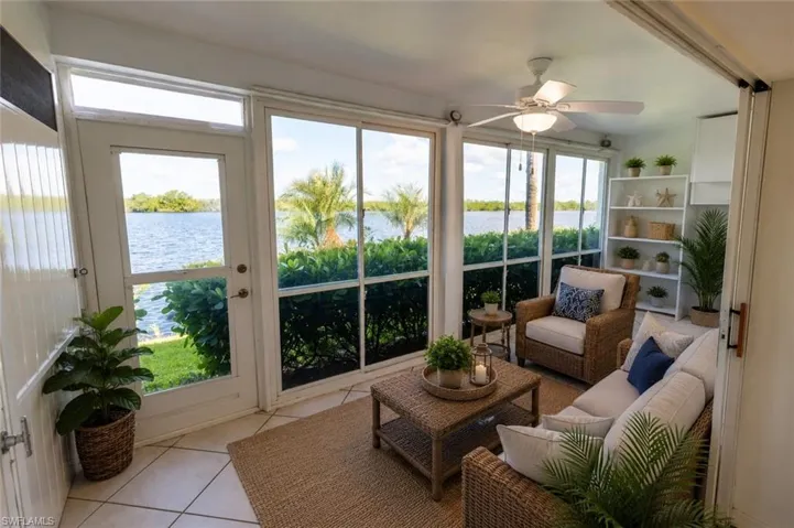 Sunroom with expansive water-facing windows and a glass-paneled exterior door