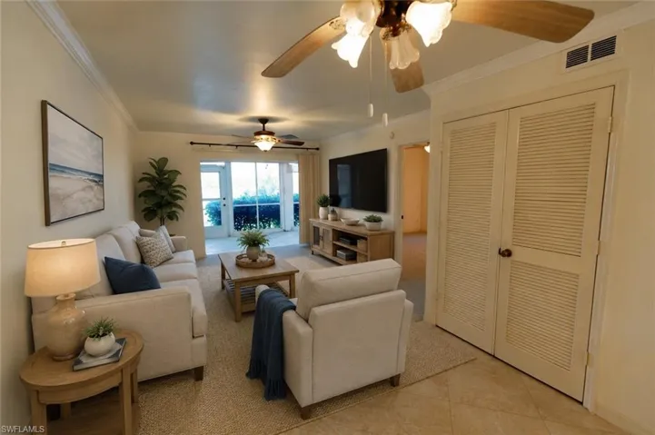 Spacious living area featuring neutral wall tones and crown molding