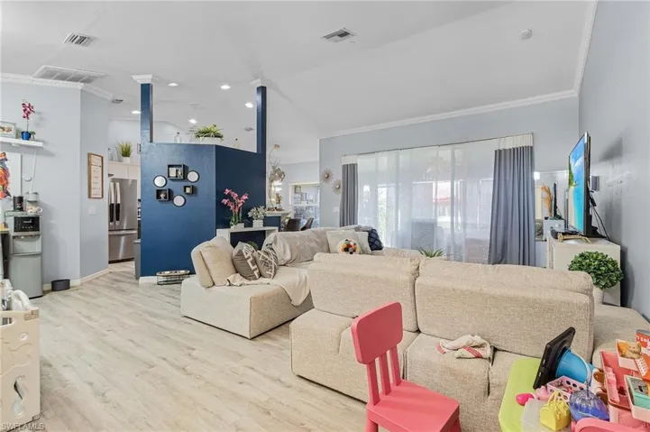Living room with ornamental molding and light wood-type flooring