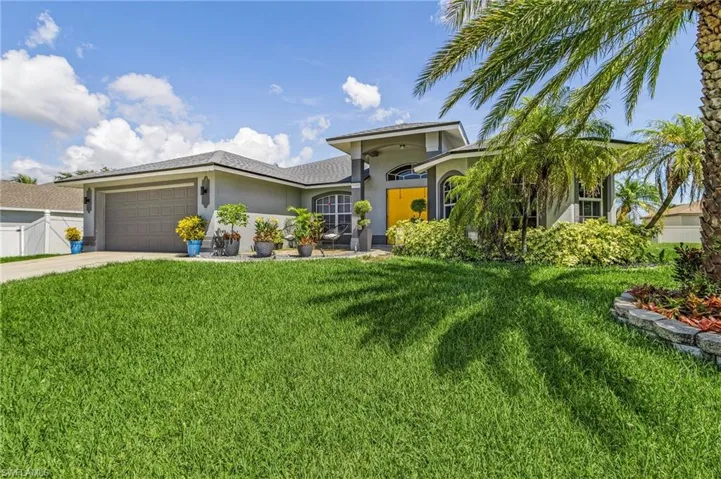 View of front facade featuring a garage and a front lawn