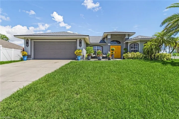 View of front of property featuring a front lawn and a garage