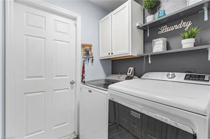 Laundry room with washer and dryer and cabinets
