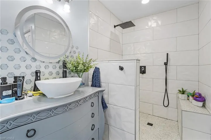 Bathroom featuring a tile shower and vanity