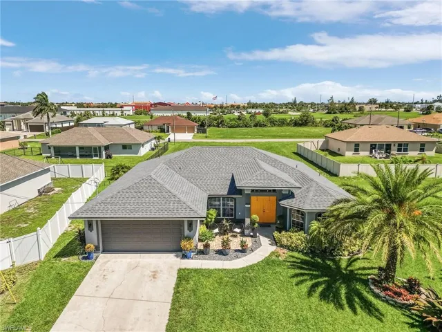 Single story home with a garage and a front yard