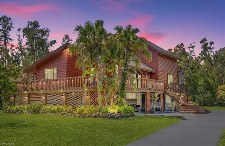 View of front of home with a lawn and a wooden deck