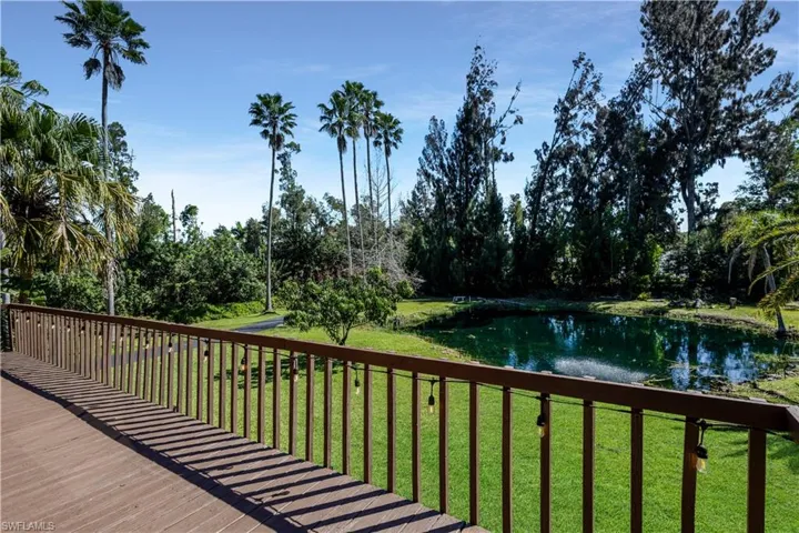 deck featuring a water view and a lawn and front pond