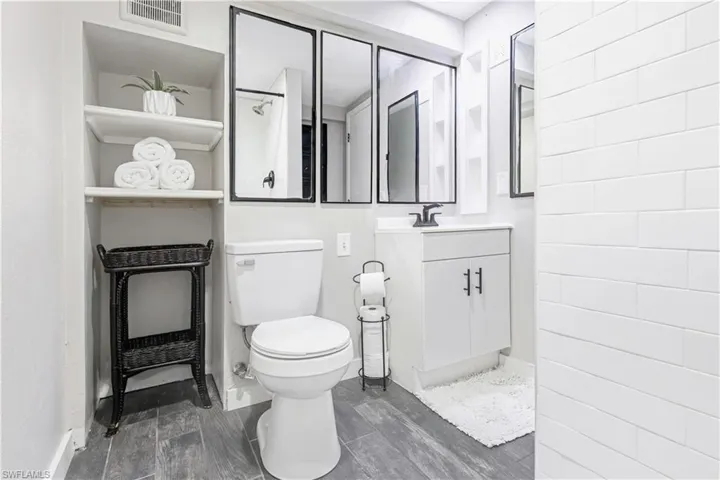 Bathroom featuring wood-type flooring, vanity, and toilet