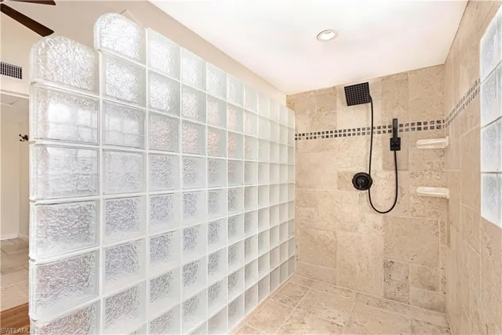 Bathroom featuring ceiling fan and tiled shower