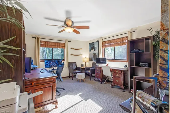 Office space with plenty of natural light, light carpet, and ceiling fan