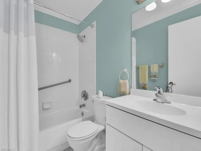 Bathroom with shower / bath combination with curtain, vanity, and crown molding
