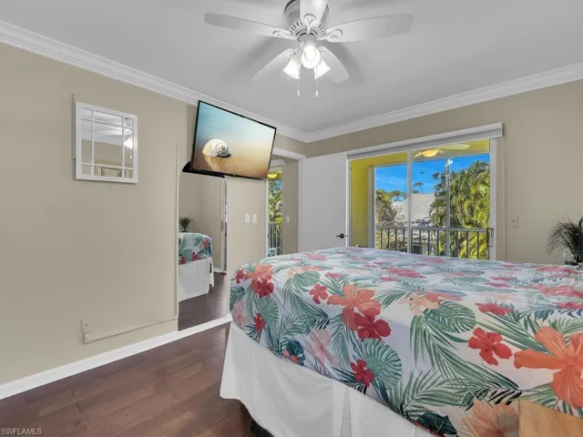 Bedroom with access to exterior, dark wood-style floors, ornamental molding, and ceiling fan