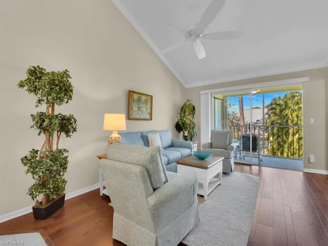 Living area featuring wood finished floors, ornamental molding, a ceiling fan, and high vaulted ceiling