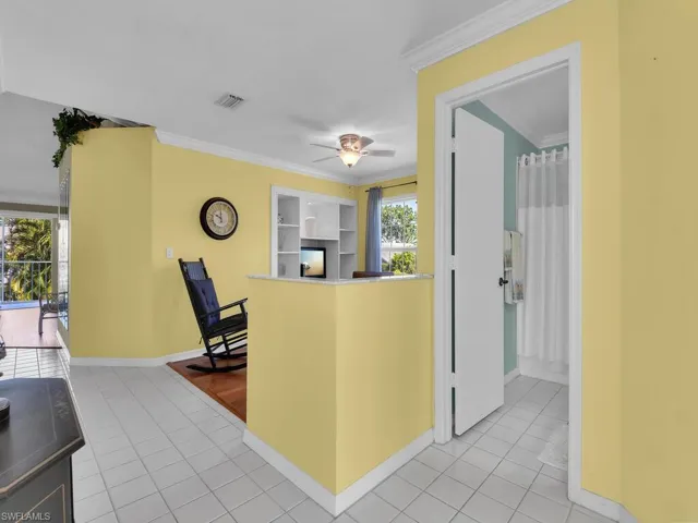Kitchen featuring crown molding, light tile patterned floors, and ceiling fan
