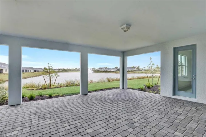 Backyard patio with exterior door leading from primary bedroom suite out onto lanai with gorgeous water view