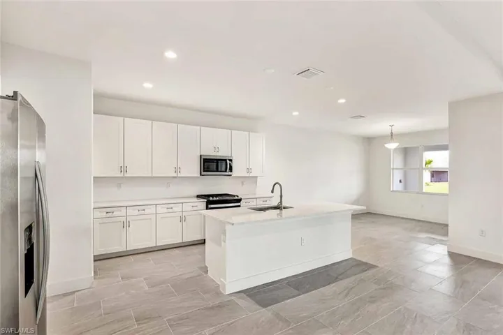 Gorgeous kitchen layout with stainless steel appliances, quartz countertops, and ample cabinetry