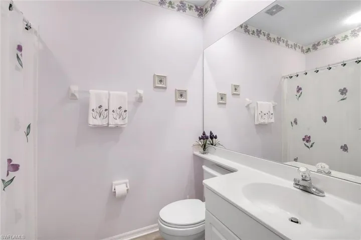 Bathroom featuring curtained shower and vanity