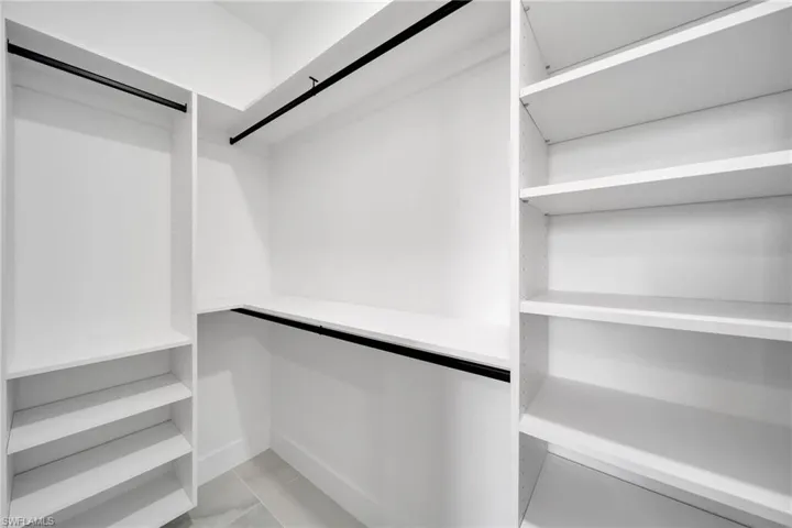 Spacious closet with light tile patterned floors
