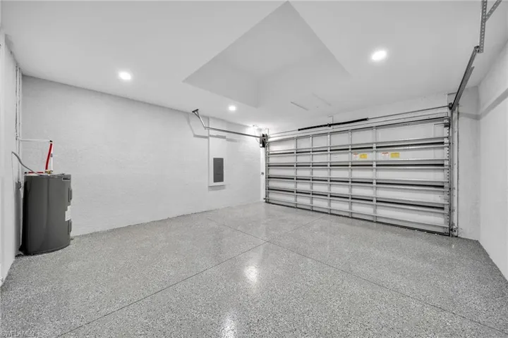Garage featuring electric water heater and electric panel